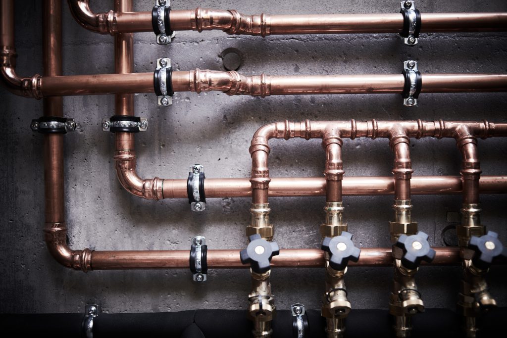 copper pipes of a private house autonomous heating system in boiler room. Plumbing services